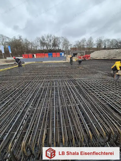 Bodenplattenbewehrung mit Arbeitern auf der Baustelle