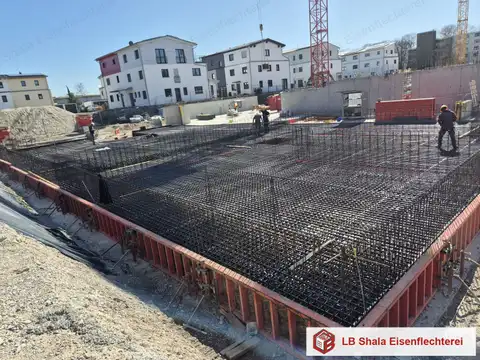 Bewehrung einer Fundamentplatte mit Eisenflechter auf der Baustelle